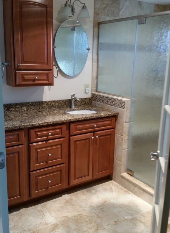 Bathroom remodel with wooden cabinets by LeFaivre Home Contractors.